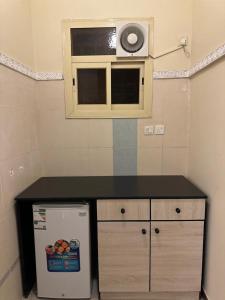 una pequeña cocina con encimera y microondas en المبيت 3 للشقق الفندقية en Abha