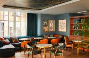 a room with a couch and tables and chairs at Hotel Indigo - Exeter, an IHG Hotel in Exeter