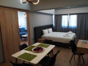 a hotel room with a bed and a table with a bowl of fruit at Urban House Aiolou in Athens