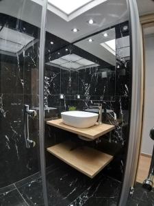a black bathroom with a sink and a mirror at Urban House Aiolou in Athens