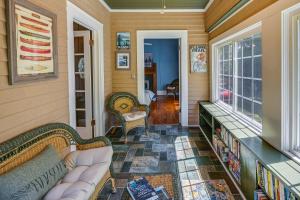 a screened in porch with a couch and books at Quaint Anderson Home with Sunroom, Walk To Downtown! in Anderson