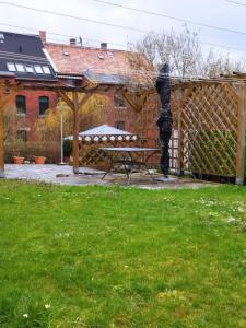 una pérgola de madera con un banco en un patio en Pension Stöß, en Falkenstein