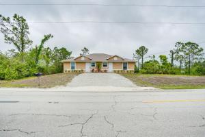 a house on a street with a driveway at Lehigh Acres Vacation Rental with Screened Patio! in Lehigh Acres