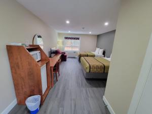 Habitación pequeña con 2 camas y cocina en Pine Motel, en Deep River