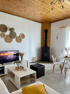 a living room with a couch and a tv and a stove at The balcony in Glossa