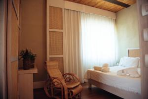 sypialnia z łóżkiem, krzesłem i oknem w obiekcie La Pampa Relais & Spa w mieście Melizzano +37 zdjęć