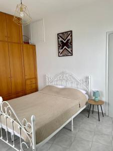 1 dormitorio con cama blanca y armario de madera en The balcony, en Glossa