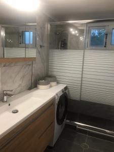 a bathroom with a sink and a washing machine at Big garden house at Itea in Kírra