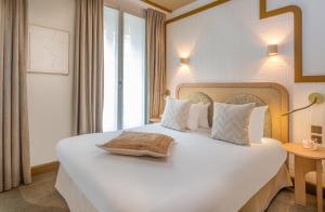 Postel nebo postele na pokoji v ubytování Hôtel Le Monna Lisa by Inwood Hotels