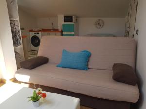un sofá con una almohada azul en la sala de estar en Apartamentos Momas La Casa De Mamá, en Málaga
