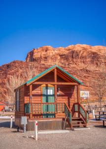 a log cabin with a mountain in the background at Sun Outdoors Arches Gateway in Moab