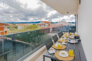 balcone con tavolo e sedie e vista di Villa Ivani a Sukošan (San Cassiano)