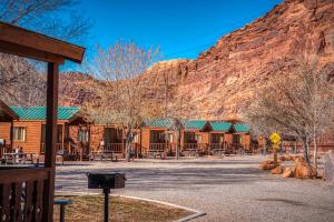 a group of wooden cabins in front of a mountain at Sun Outdoors Arches Gateway in Moab