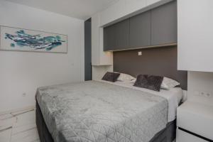 una camera da letto con un letto grande con due cuscini sopra di Villa Ivani a Sukošan (San Cassiano) Altre 40 foto