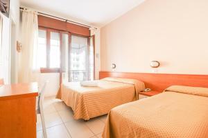 a hotel room with two beds and a window at Hotel Jesulum in Lido di Jesolo