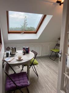 stół i krzesła w pokoju z oknem w obiekcie Appartement entier en résidence centre ville w mieście Vendôme