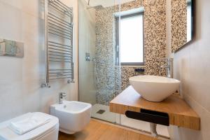 un bagno con lavandino, wc e doccia di Twelve12 - Università & Stazione Aparment a Bari Altre 12 foto