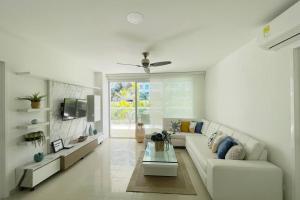 a white living room with a couch and a tv at LUJOSO Apartamento en Cartagena Incluye Servicio Domestico in Cartagena de Indias