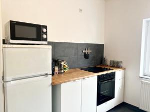 una cucina con frigorifero bianco e forno a microonde di Helle, gemütliche Ferienwohnung in Bremerhaven a Bremerhaven