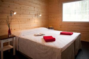 een slaapkamer met een bed met twee rode handdoeken erop bij Villa Valmuska in Mikkeli
