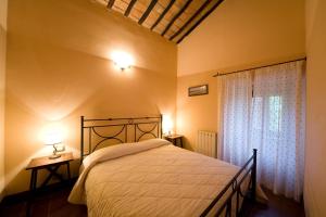 a bedroom with a bed and a window at Antico Borgo Poggiarello in Monteriggioni