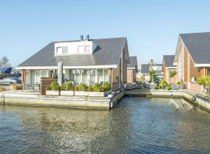 una casa sentada en un río con casas en Meerzicht 99 - Luxury house 30 minutes from Amsterdam, en Uitgeest