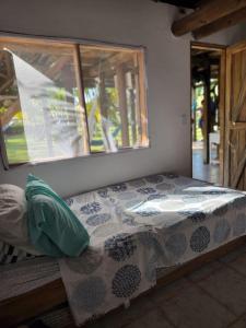 a bed sitting in a room with a window at Cabana Ferrer in Notecebes +12 photos
