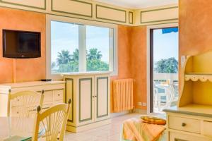 una cucina con pareti arancioni e tavolo e sedie di A6- 3p Antibes Garoupe vue mer terrasse clim garage a Antibes