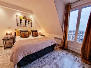 ソミュールにあるLes Terrasses de Saumur - Hôtel & Appartements - Restaurant & Spa (Logis)のベッドと大きな窓のある寝室