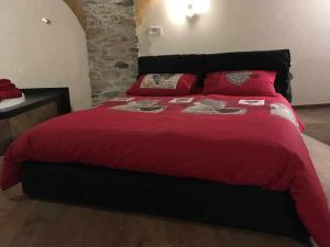 a bedroom with a large red bed with red pillows at Lo Bòi Avise in Avise