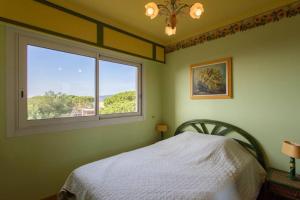 1 dormitorio con cama blanca y ventana en A6- 3p Antibes Garoupe vue mer terrasse clim garage en Antibes