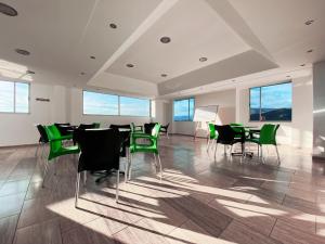 アキタニアにあるHotel 3.015 Aquitaniaの緑の椅子とテーブル、窓が備わる客室です。