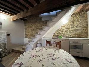 una cucina con tavolo e parete in pietra di La casetta nel Borgo -Cerageto- a Cerageto