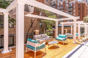 a patio with chairs and tables on a building at Fantastic 1 Bedroom Condo At Ballston With Gym in Arlington
