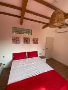 ZagaroloにあるCasa di Milaのベッドルーム(赤い枕の大きな白いベッド付)