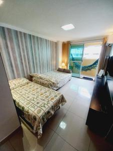 a hotel room with two beds and a window at Cabo Branco Dream in João Pessoa