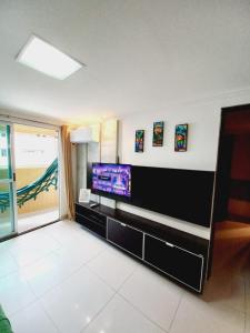a living room with a flat screen tv on a wall at Cabo Branco Dream in João Pessoa