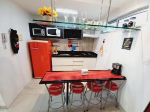 una cocina con encimera roja y taburetes rojos en Cabo Branco Dream en João Pessoa