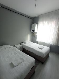 two beds in a small room with a window at Sweet Home in Historical Area 3B in Istanbul
