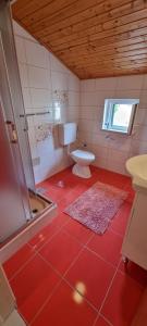 a red bathroom with a toilet and a shower at Apartmani S&S in Stara Novalja