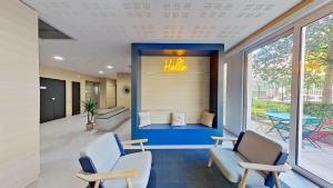 an office lobby with two chairs and a table at City Résidence Paris Saint-Maurice in Saint-Maurice