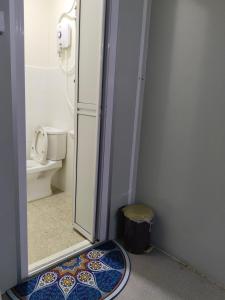 a bathroom with a shower and a toilet and a rug at Casa LiLa Tiny Stay & Pool Kota Bharu,free wifi,free parking 
