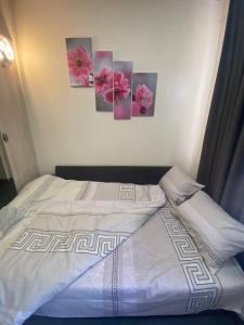 a bedroom with a bed with four paintings on the wall at Luxury Room_Karavaeva in Dnipro
