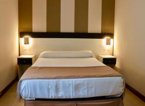 1 dormitorio con 1 cama grande y 2 mesitas de noche en Playa Home Helgueras con acceso a Spa (AguaMarinaSpa) en Noja