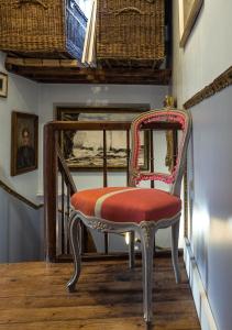 una silla en un pasillo con espejo en Chambres d'hôtes Villa l'espérance, en Étretat