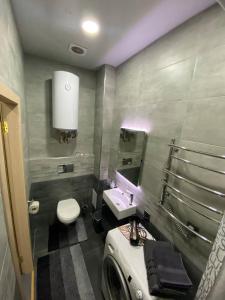 a bathroom with a sink and a toilet and a mirror at Luxury Room_Karavaeva in Dnipro