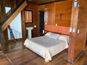 1 dormitorio con 1 cama en una habitación con paredes de madera en CASA PARAISO, en Puerto Morelos