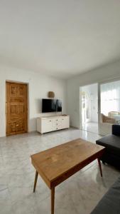 a living room with a wooden table and a couch at Casita Pepe in Jávea