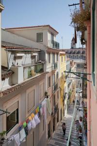 une rue étroite avec des cordes à linge et des serviettes suspendues aux bâtiments dans l'établissement Lisboa nova Central - bica 2E, à Lisbonne