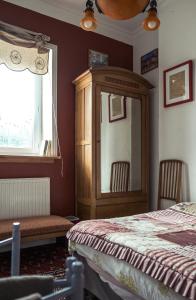 een slaapkamer met een bed, een kast en een raam bij Chambres d'hôtes Villa l'espérance in Étretat